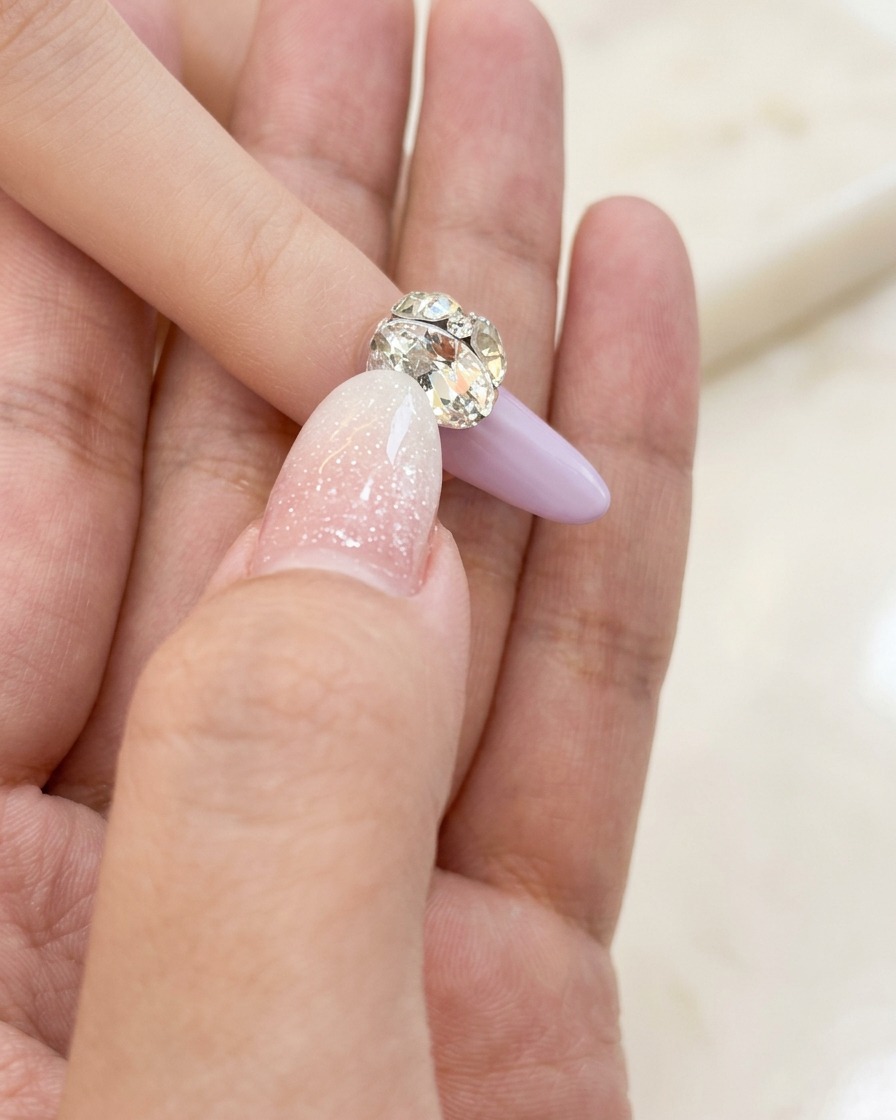 A small nail art brush carefully applying a thin layer of clear base gel onto the natural nail plate.