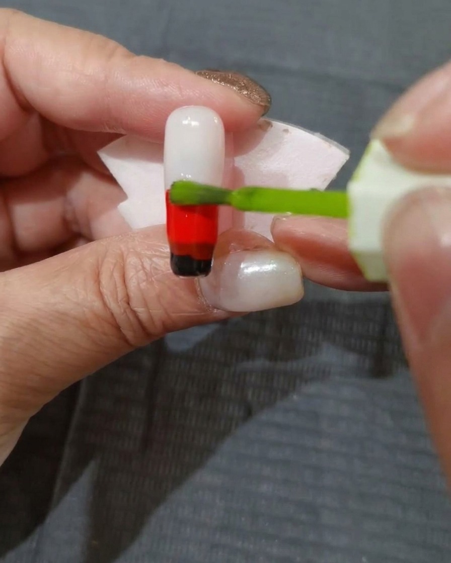 A layer of yellow-green gel polish being applied to the top portion of the nail.