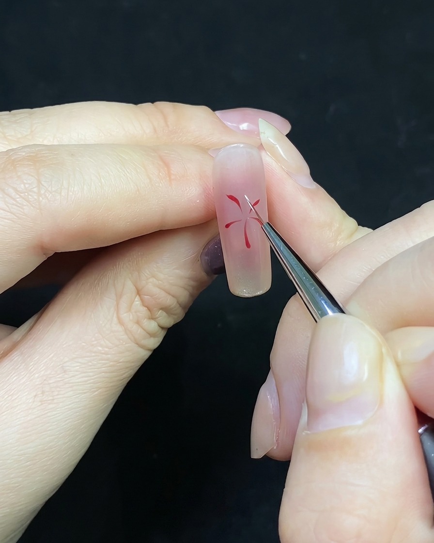 A detail brush adding white lines between existing red lines on a firework nail art design.