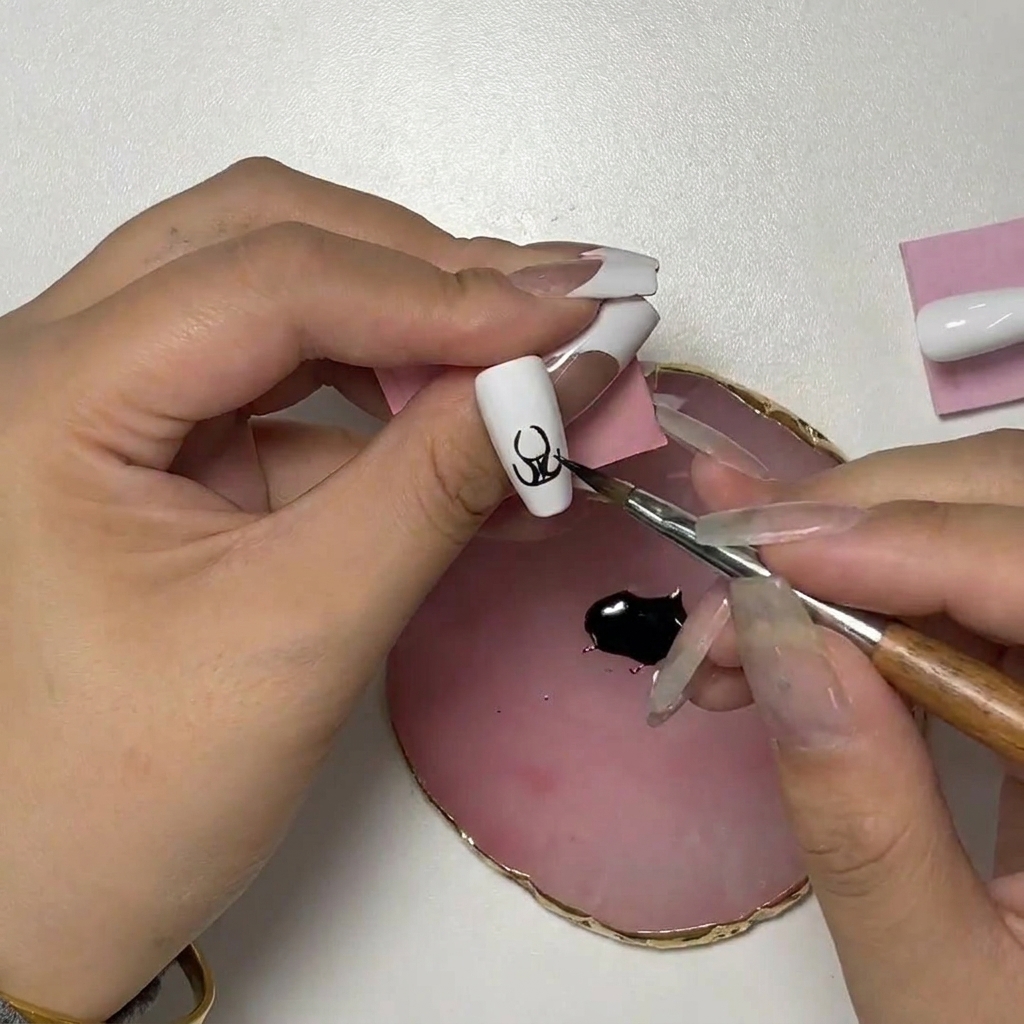 A close-up of the nail art showing the brush adding upward-curving strokes to form the tips of the flame.