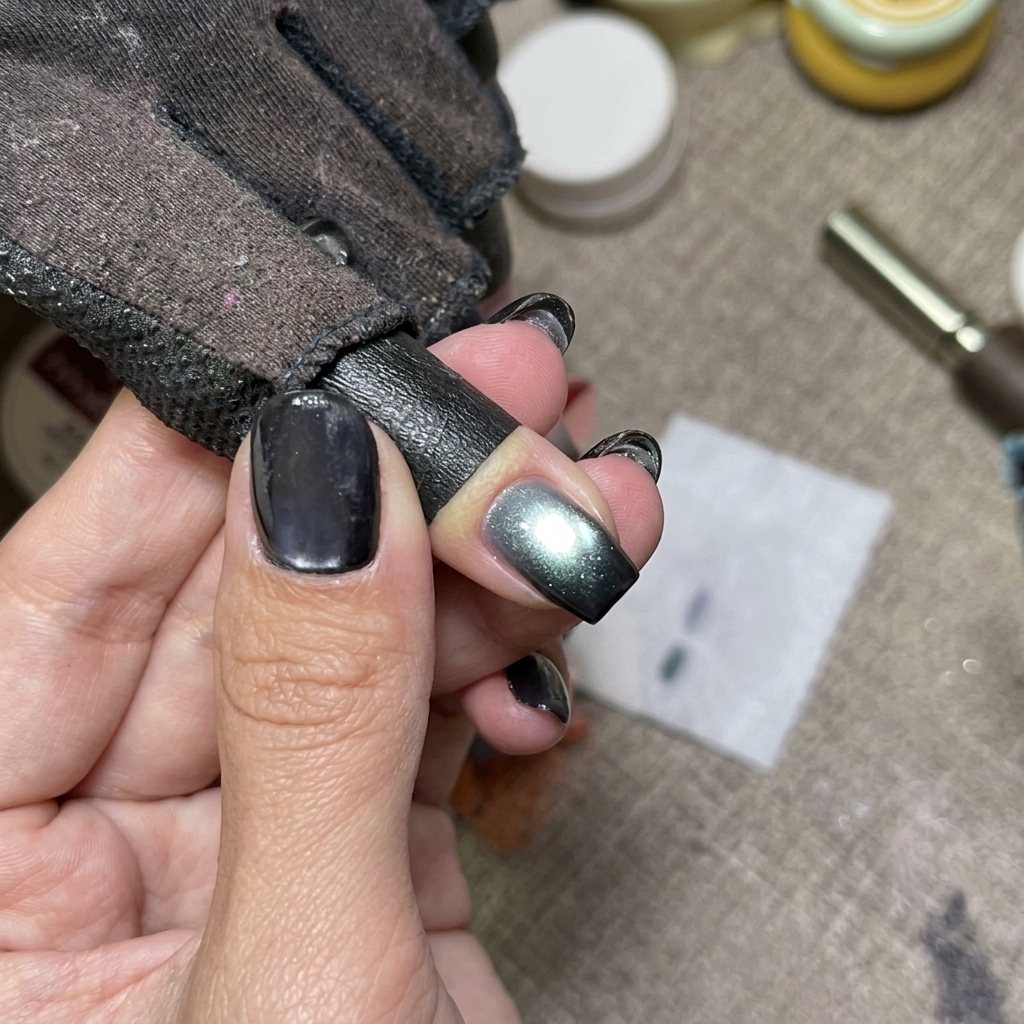 Blue cat eye nails curing under a UV nail lamp.