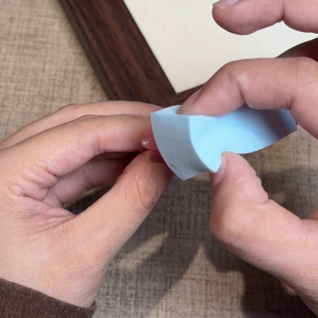 A close-up view of a sponge dabbing gel polish onto the tip section of the nail.