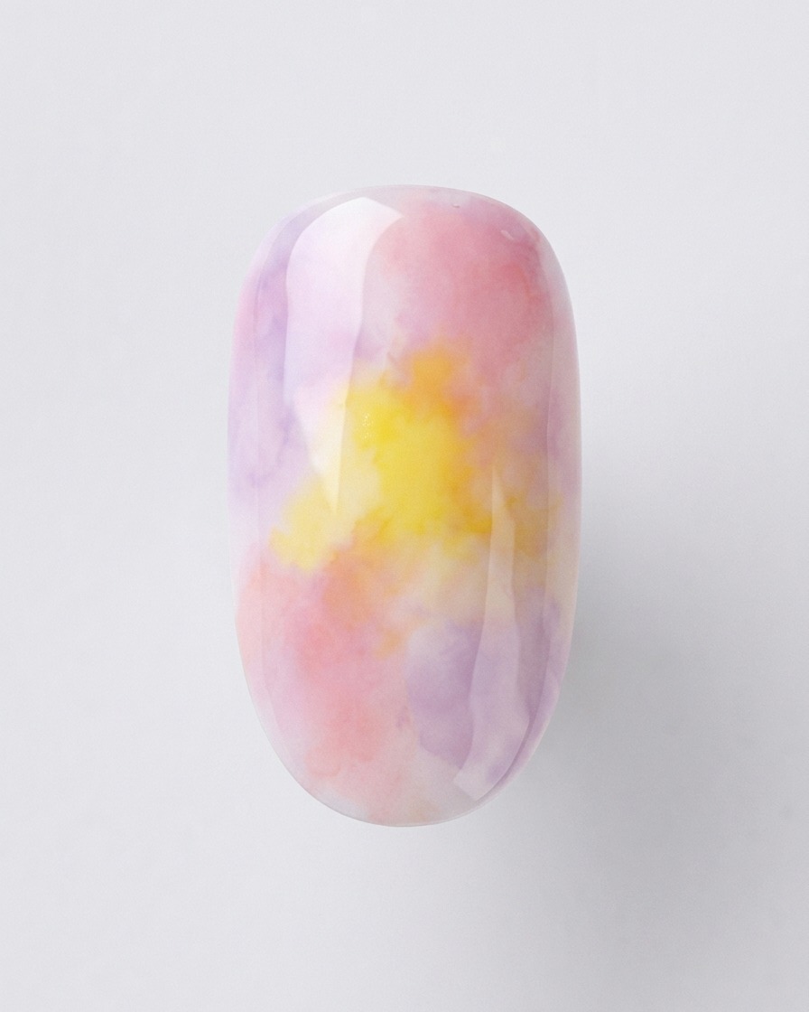 A detail shot showing silver holographic glitter being lightly applied to the tip of a sunset-gradient nail.