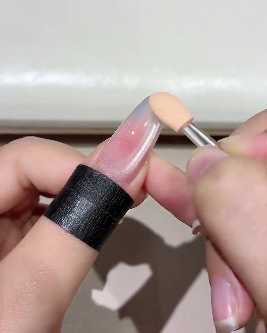 A manicured nail with a base layer of Jade D05 gel curing inside a UV/LED lamp.