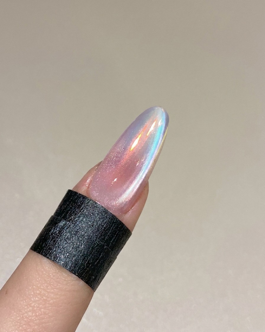 A finished cat eye nail design curing inside a professional UV/LED lamp.