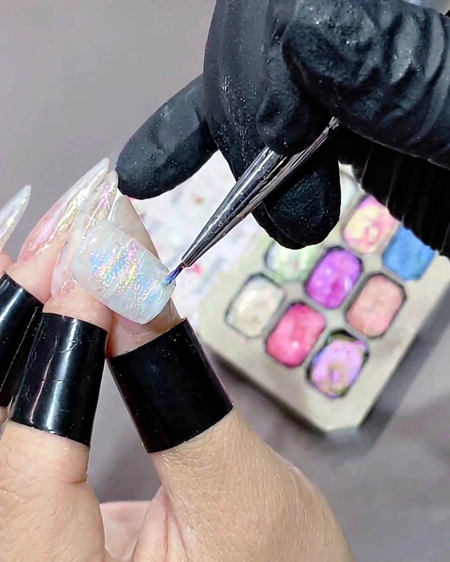 A nail with a freshly applied textured, marbled gel design being placed into a UV curing lamp.