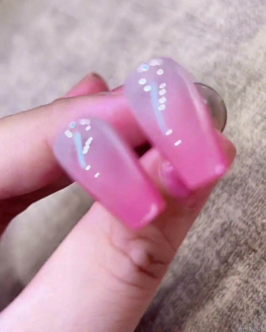 A hand resting inside a UV nail lamp with the light illuminating the fingers.