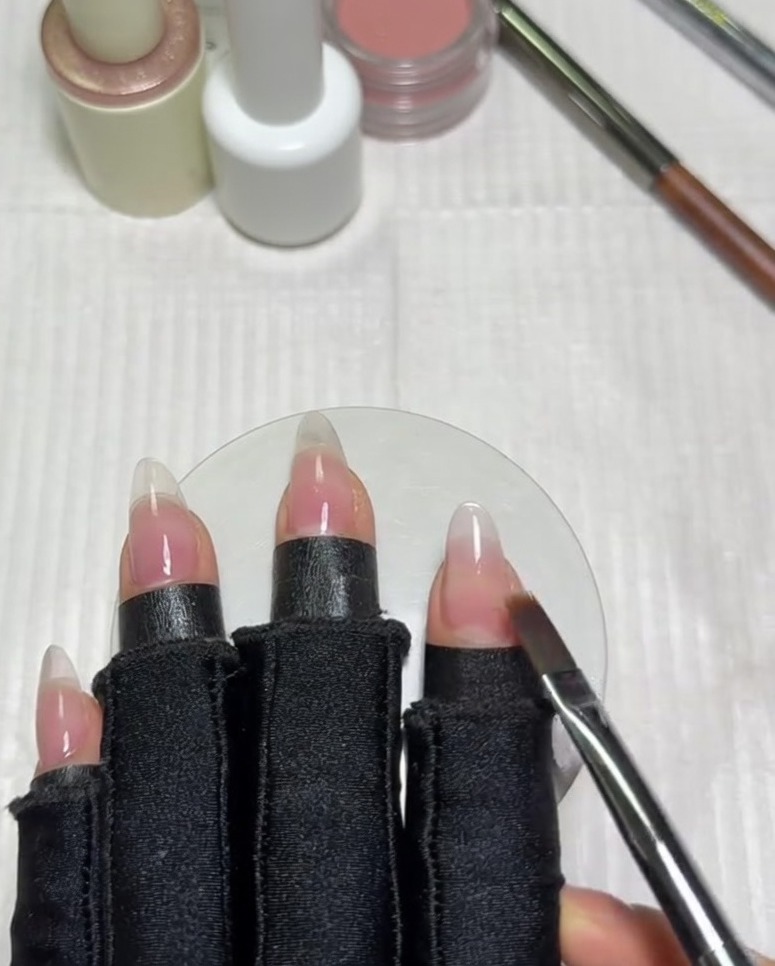 A flat gradient brush sweeping horizontally across the nail to blend the edge of the milky white gel polish into the nude base.