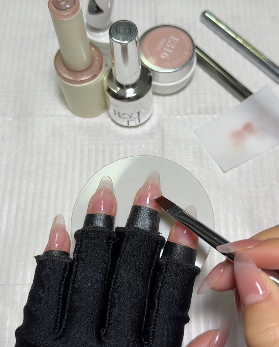 A close-up of a gradient brush being wiped clean on a white cotton pad.