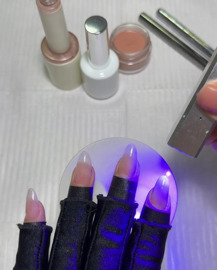A flat gradient brush blending a white gel layer on a fingernail.