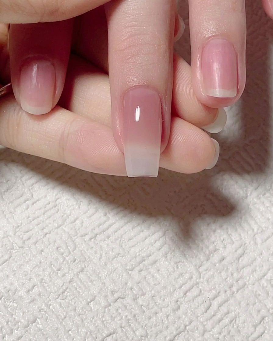A flat brush blending the jade-tinted gel upward to create a smooth, soft gradient transition on the nail.