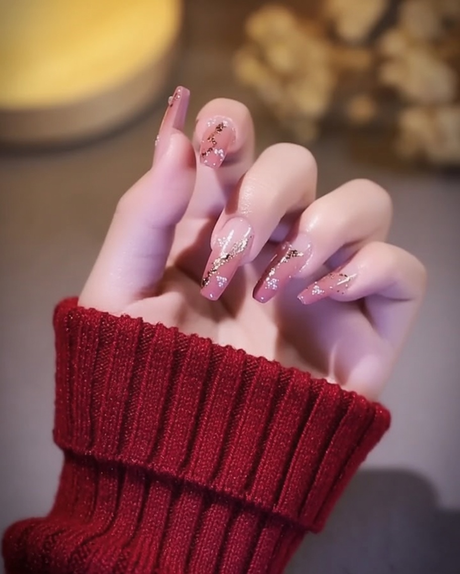 Nails with gold foil accents being cured under a UV/LED nail lamp.