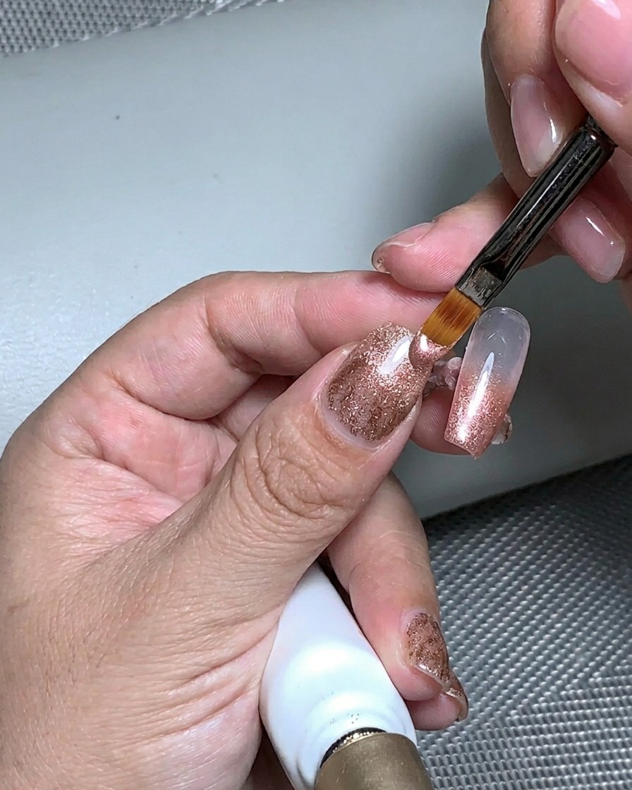 A hand placed under a UV lamp to cure the structural gel layer.