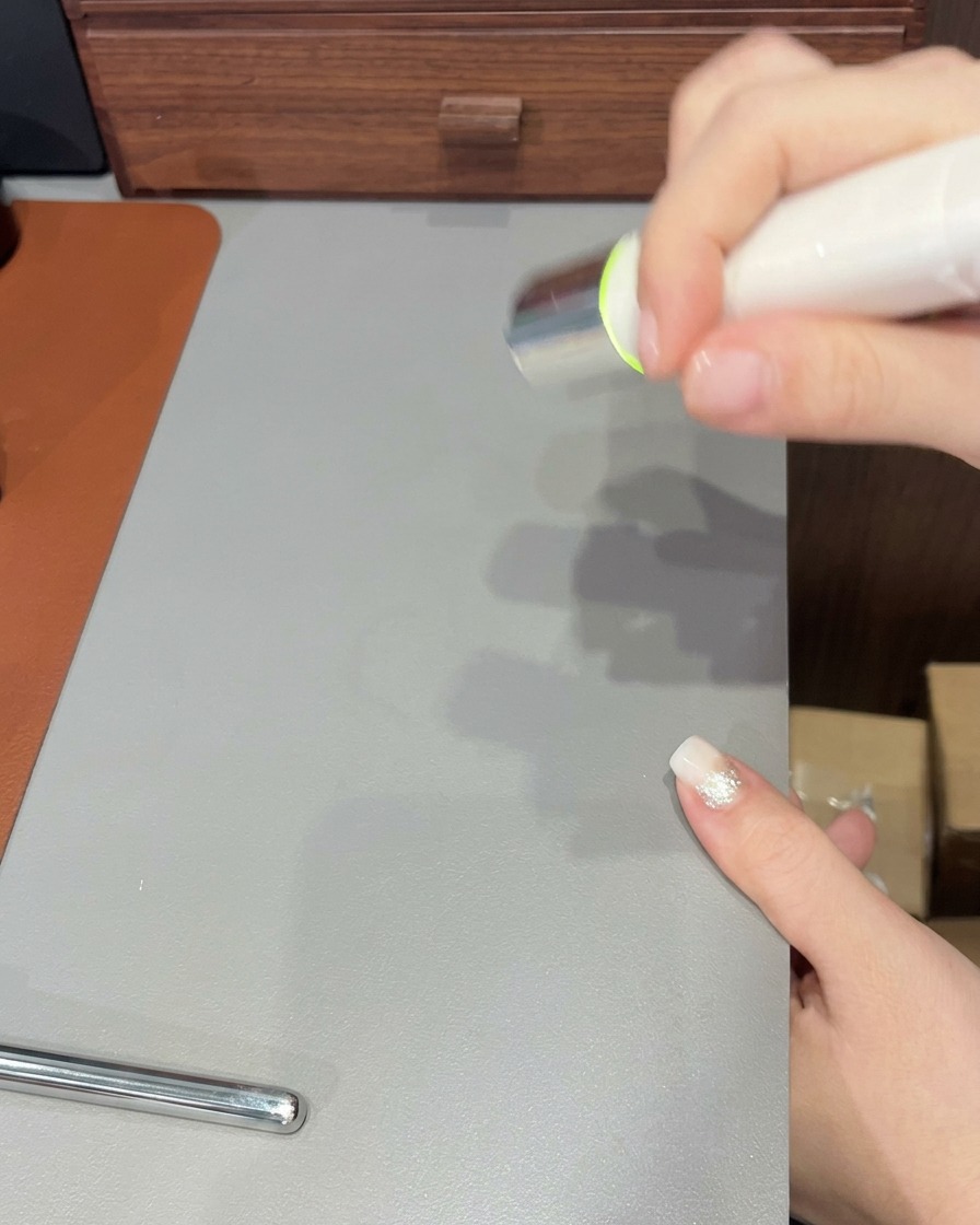 A nail brush applying a final, clear layer of gel over a completed gradient-tipped nail.