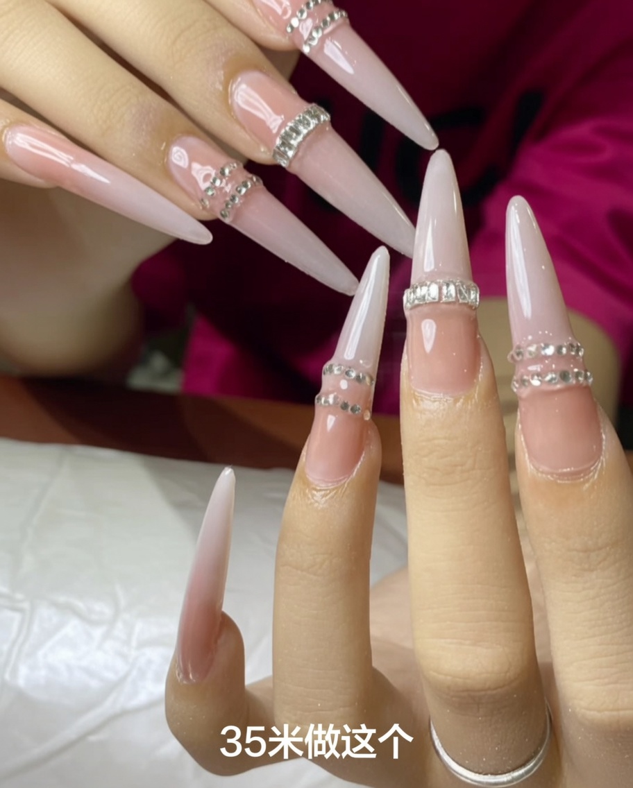 A hand placing a nail tip onto the finger and positioning it under a small UV lamp.