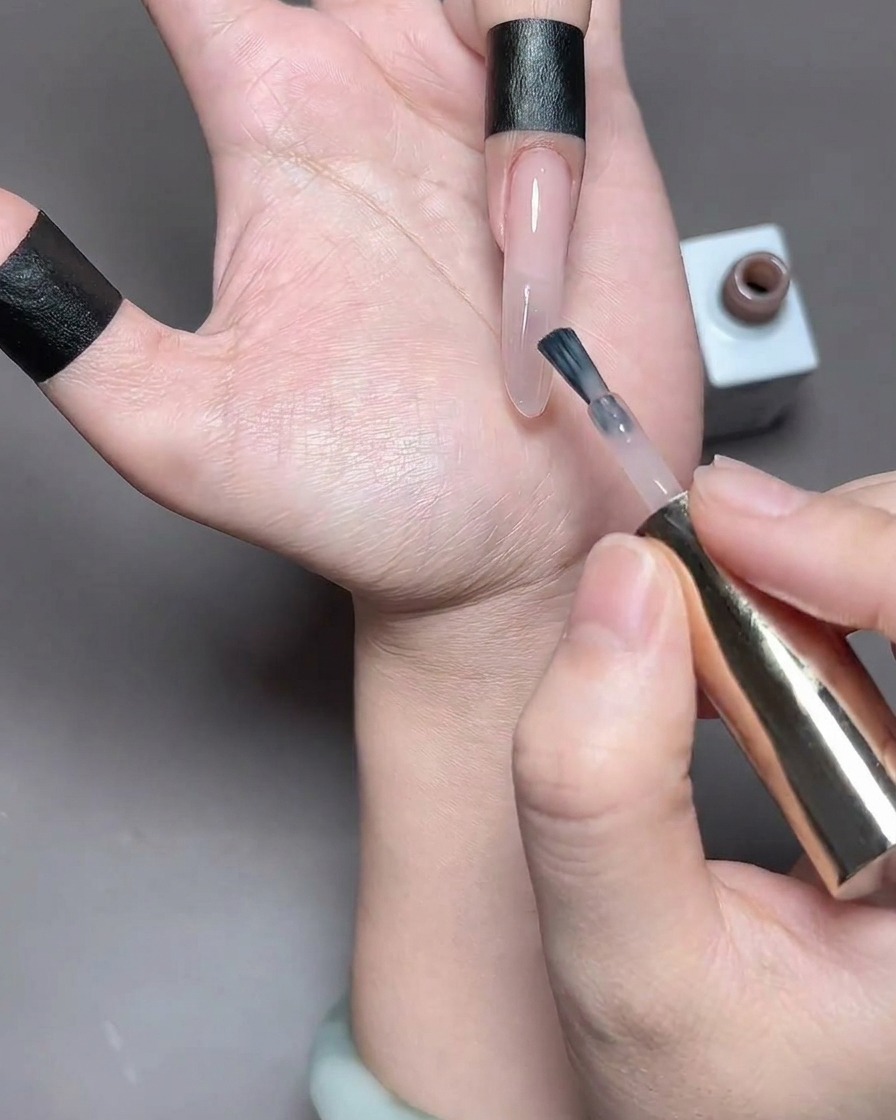 A finger with freshly applied gel polish positioned inside a nail lamp for curing.