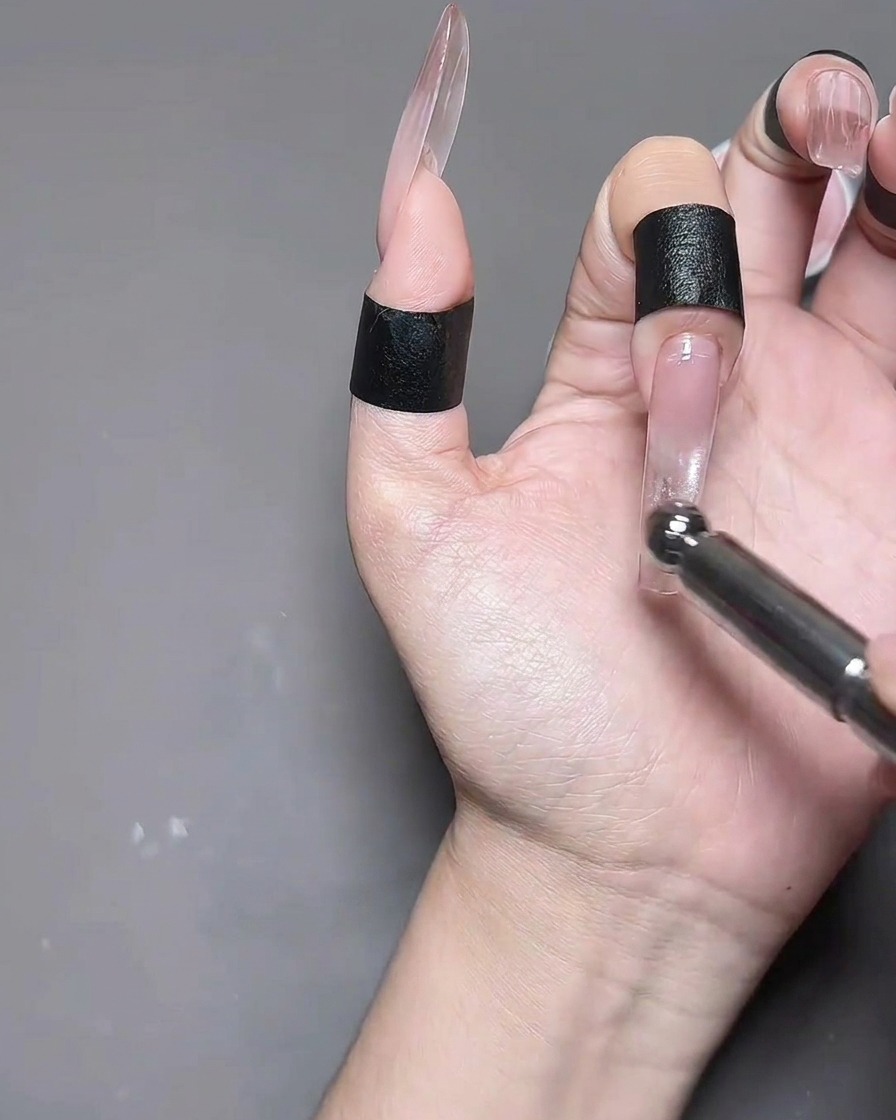 A hand with cat eye gel nails placed inside a professional nail lamp for curing.