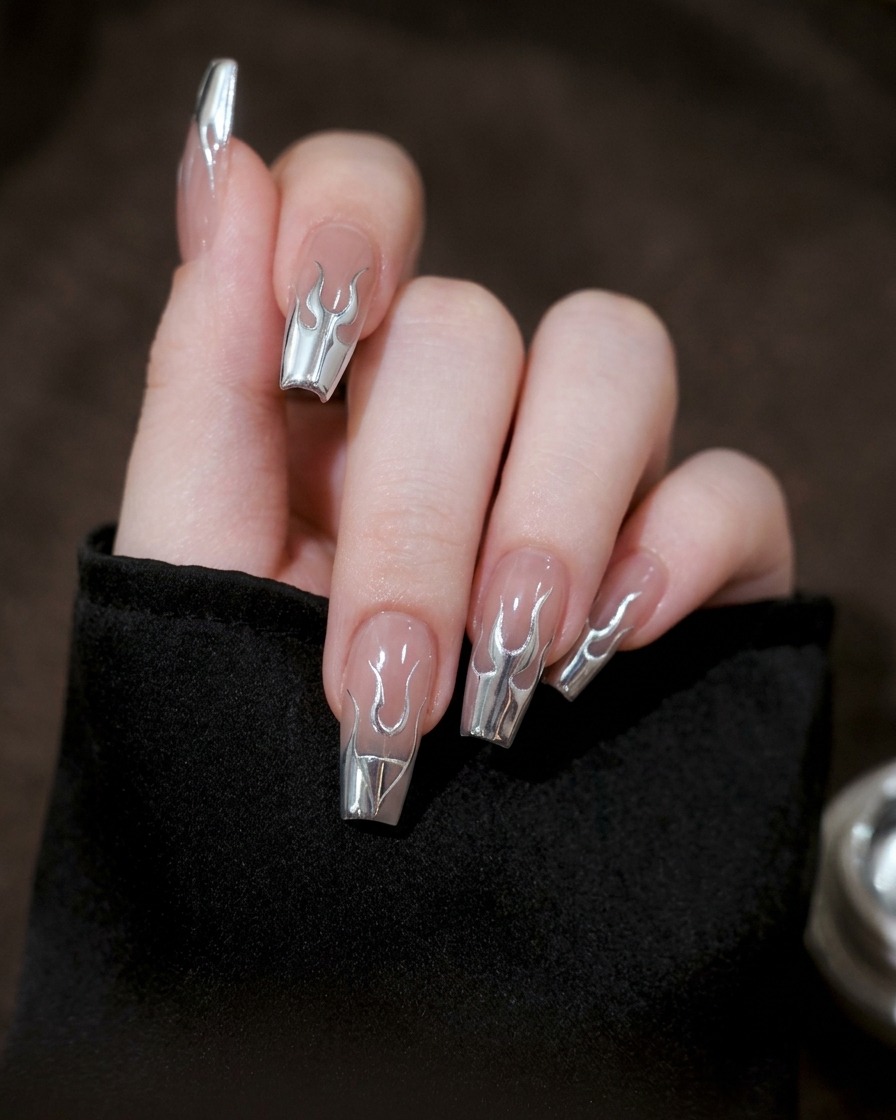 A close-up of a nail where the silver gel lines are being connected to form a complete flame silhouette.
