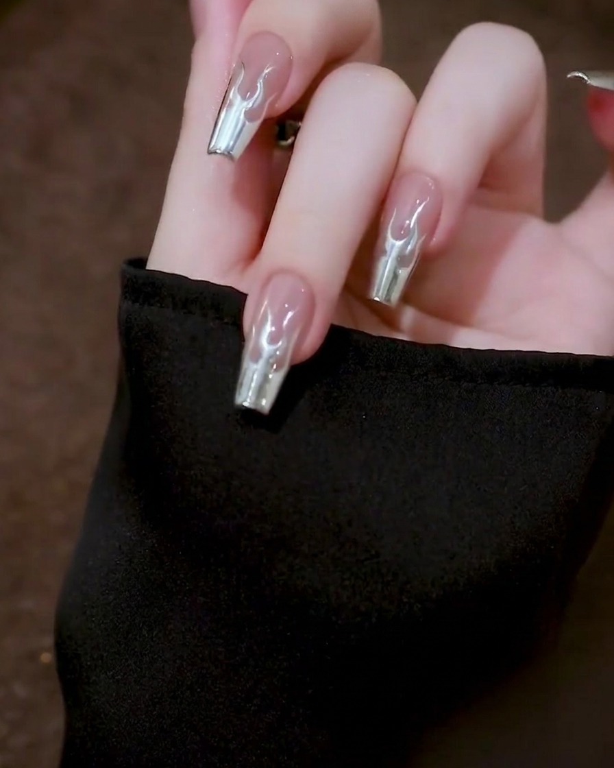 A top-down view of a hand holding a nail steady while the metallic gel on the nail surface settles and self-levels to a smooth finish.