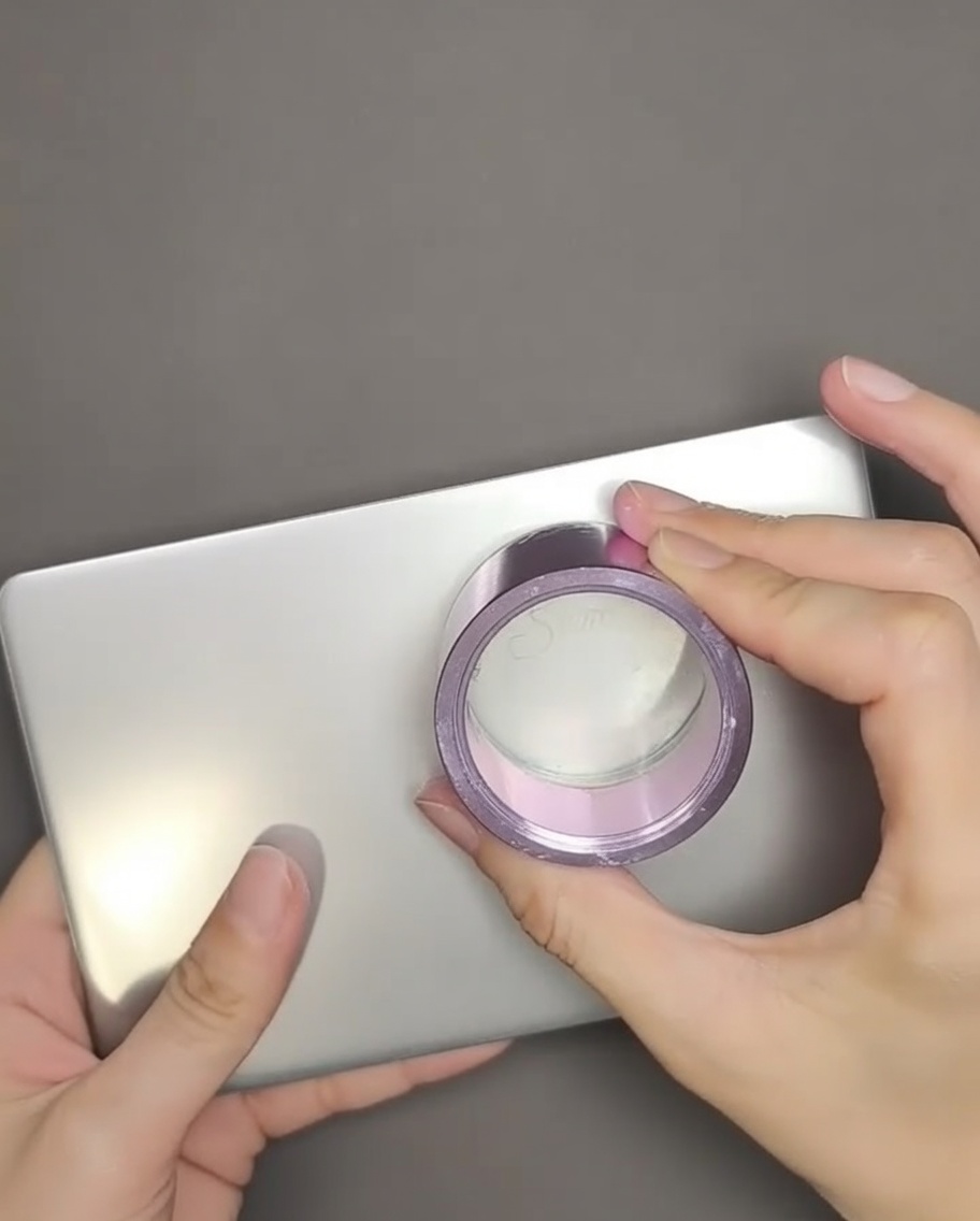 A clear silicone stamper pressing down onto an English text design on a metal stamping plate.