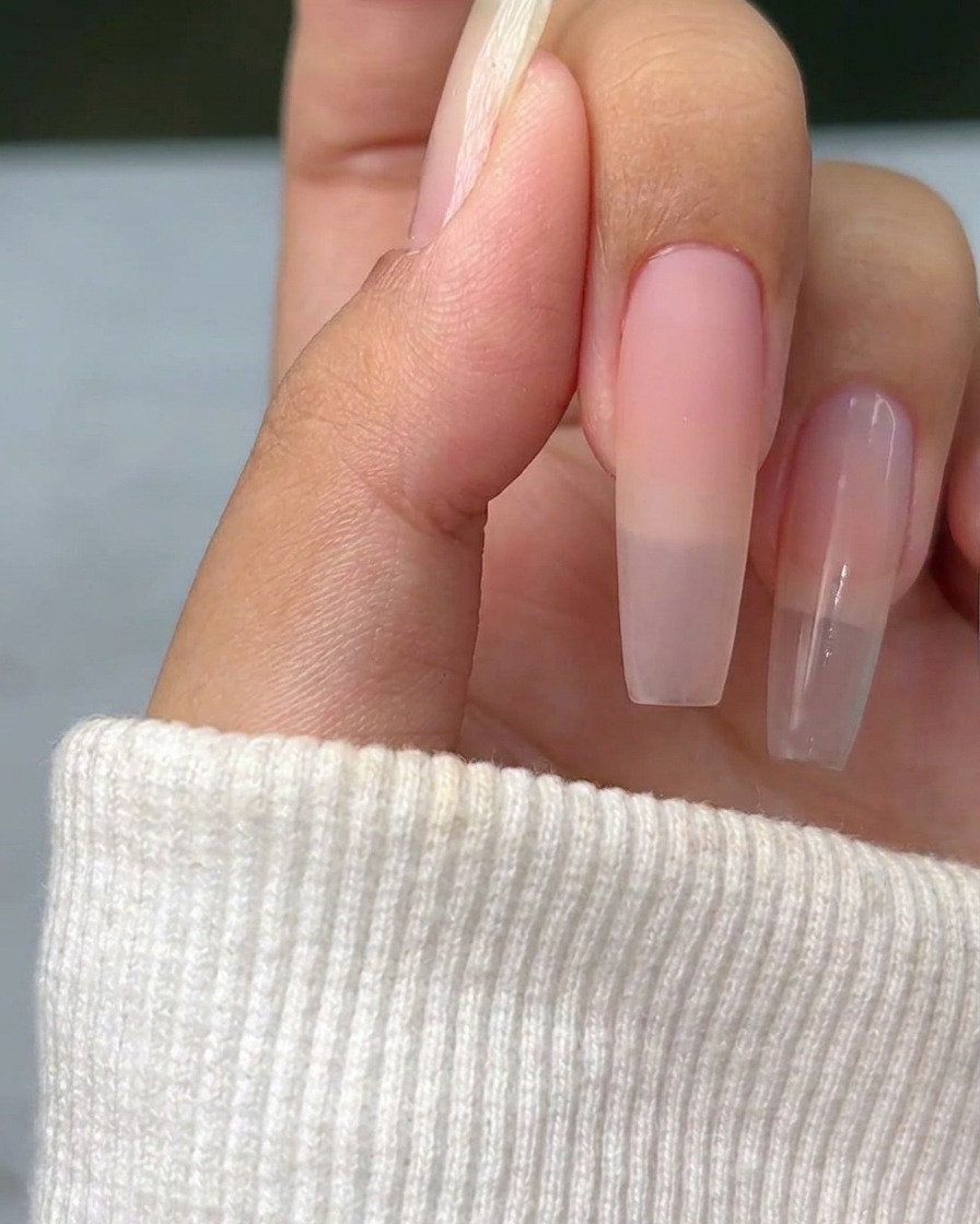 A thin metallic silver cross painted on a natural nail surface, serving as a guideline for subsequent nail art.