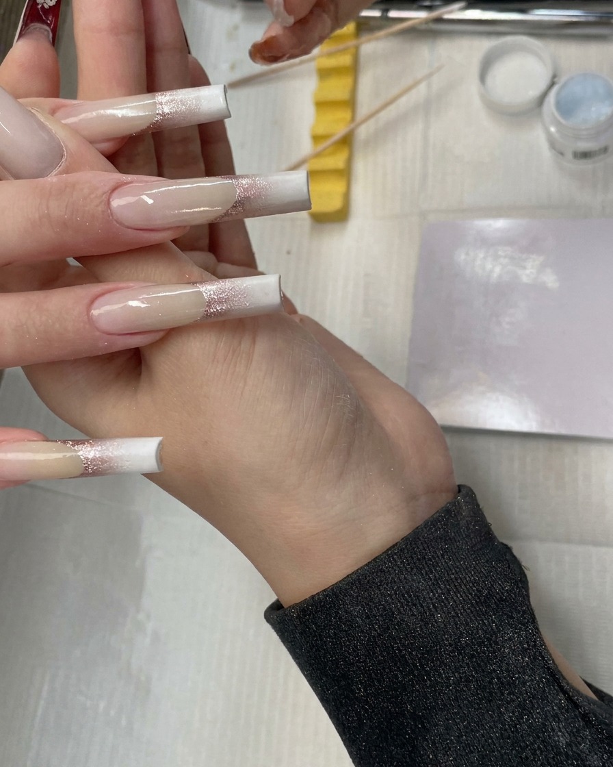 A close-up view showing the blended white and nude ombre transition on the nail surface.