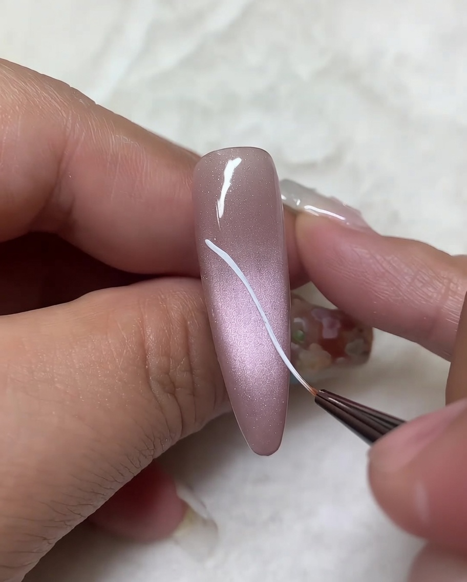 A fine liner brush adding curved lines to the previously drawn diagonal wing outlines to complete the top wing shape.