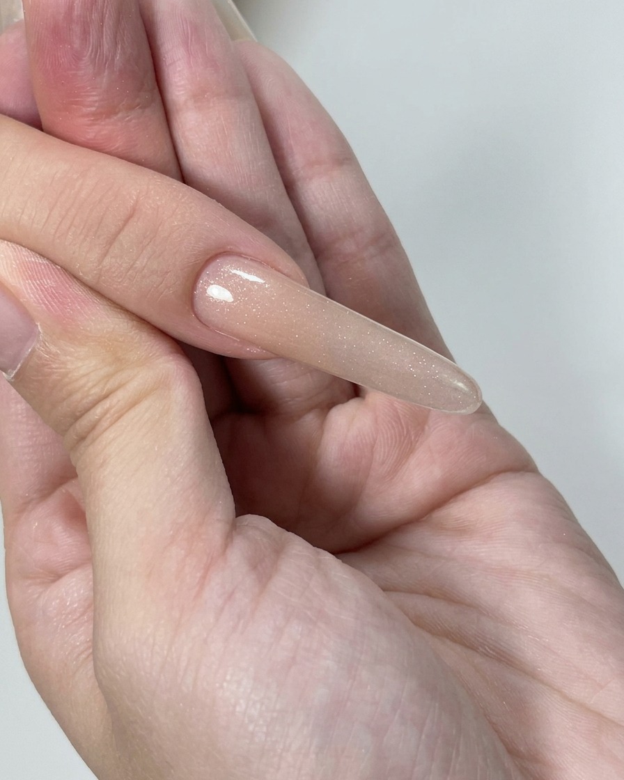 Close-up of a buffer tool being used to refine the surface of the gel nails for a smooth, uniform appearance.