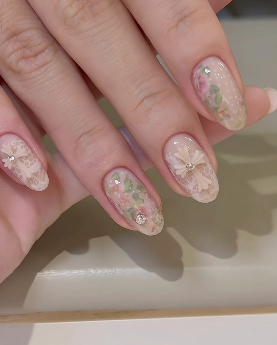 A brush applying a clear, glossy gel layer over a nail decorated with a transfer foil rose design.