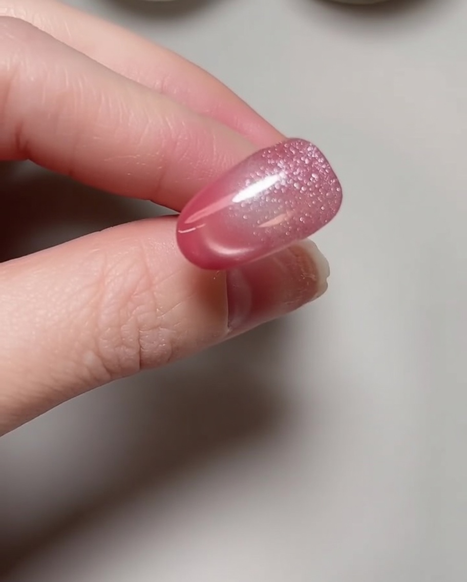 A close-up view of a nail file being used to shape the free edge of a natural nail.