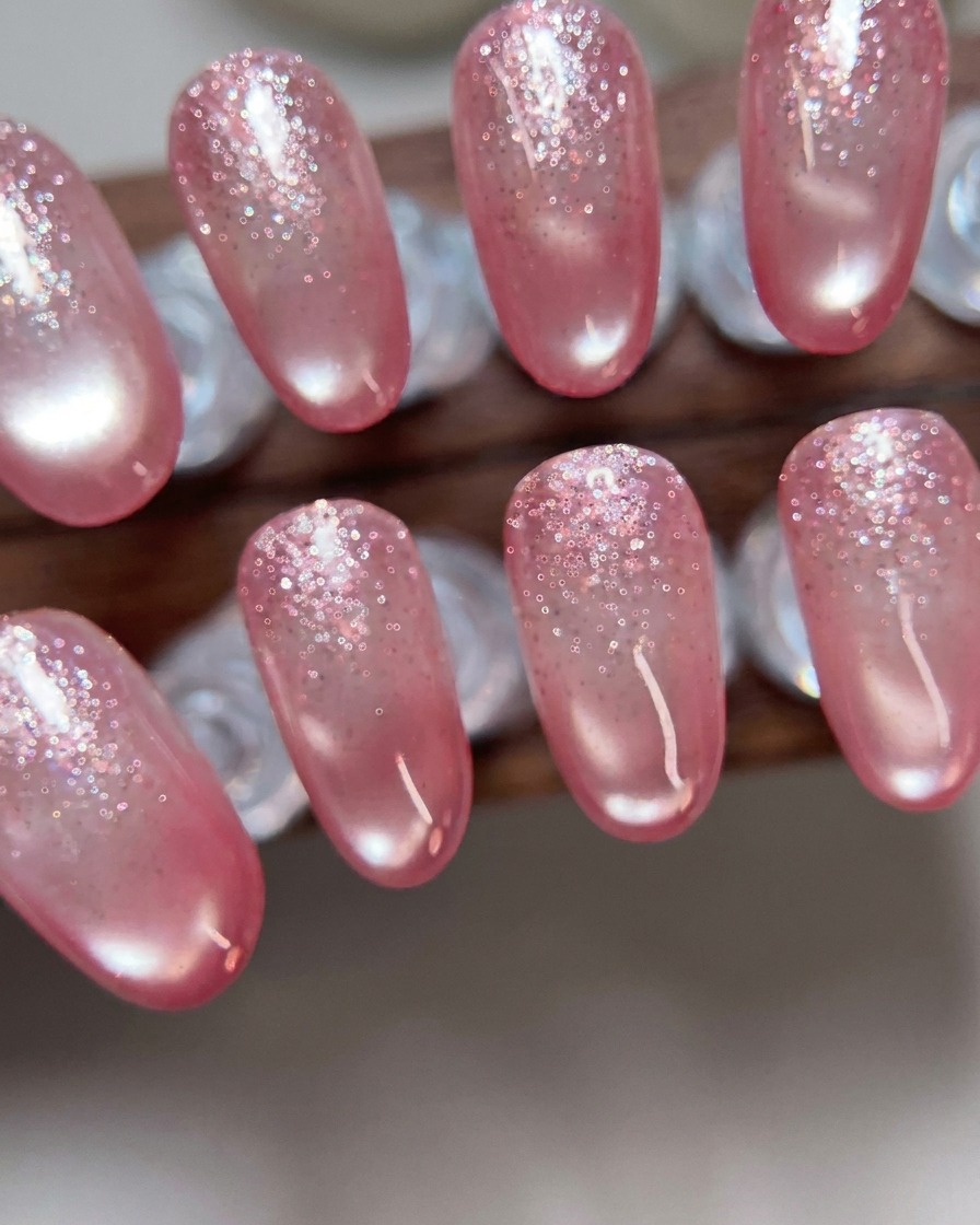 A metal cuticle pusher being used to gently push back cuticles on a prepared nail.