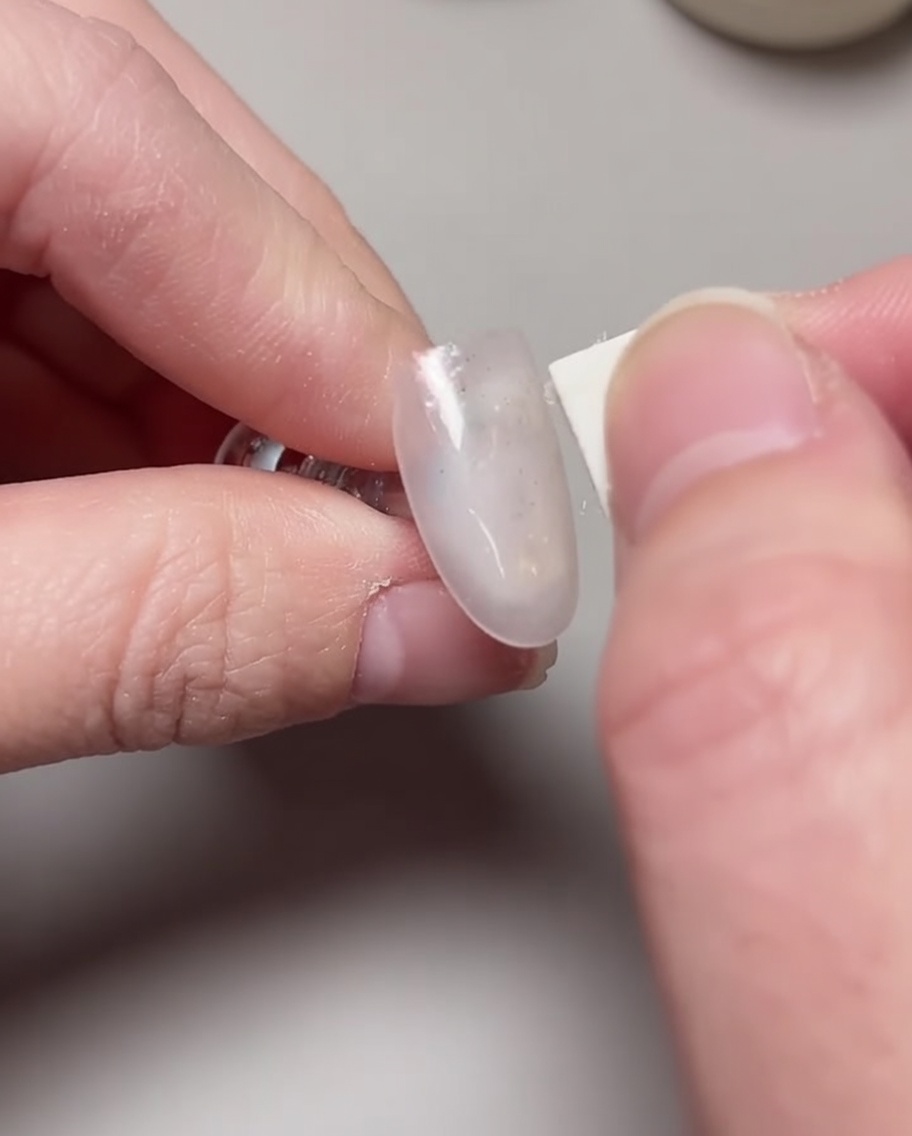 A brush applying a second layer of rose lychee gel polish to build opacity.