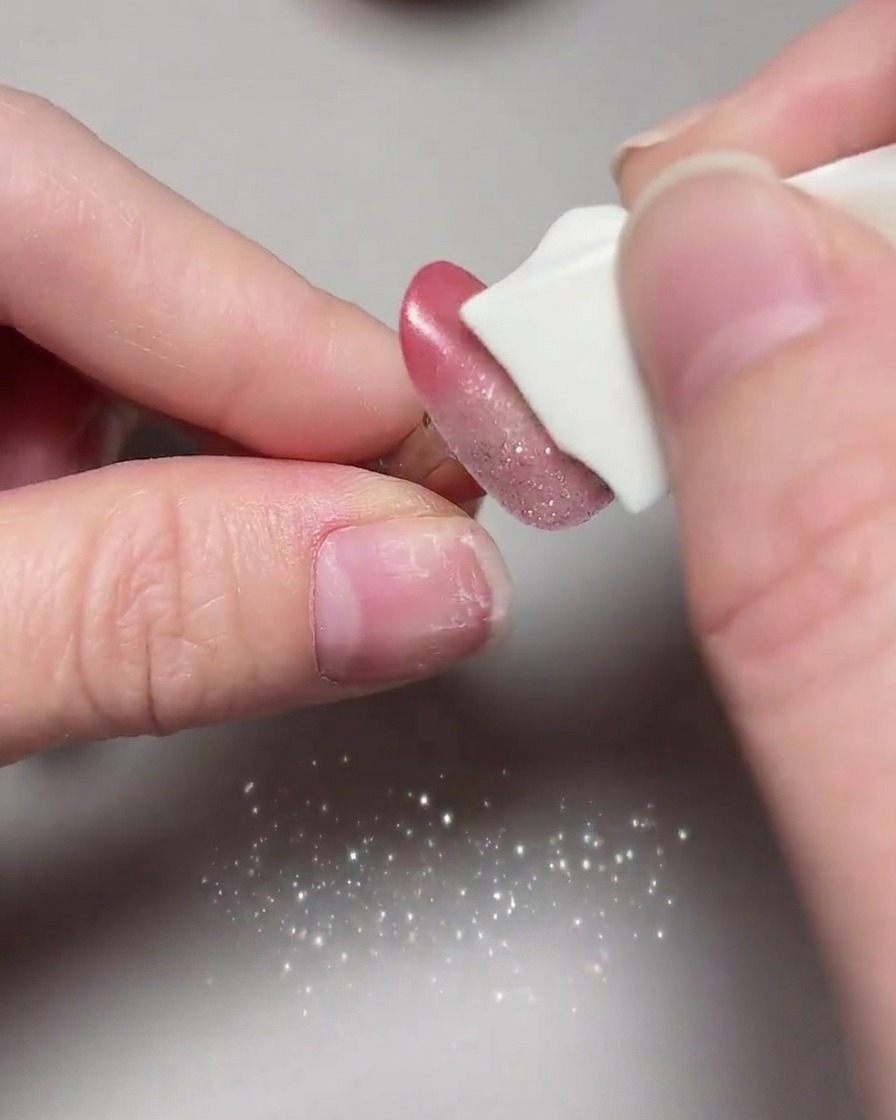 A close-up of finished cat eye nails undergoing their final cure inside a UV/LED lamp.