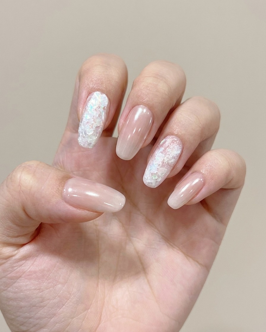 A close-up showing a sponge applying a soft color gel to the tip of a nail to create an ombre effect.