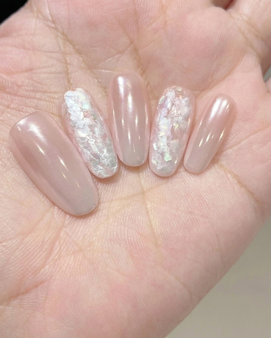 Applying a clear, thick adhesive gel to the nail in preparation for nail art embellishments.