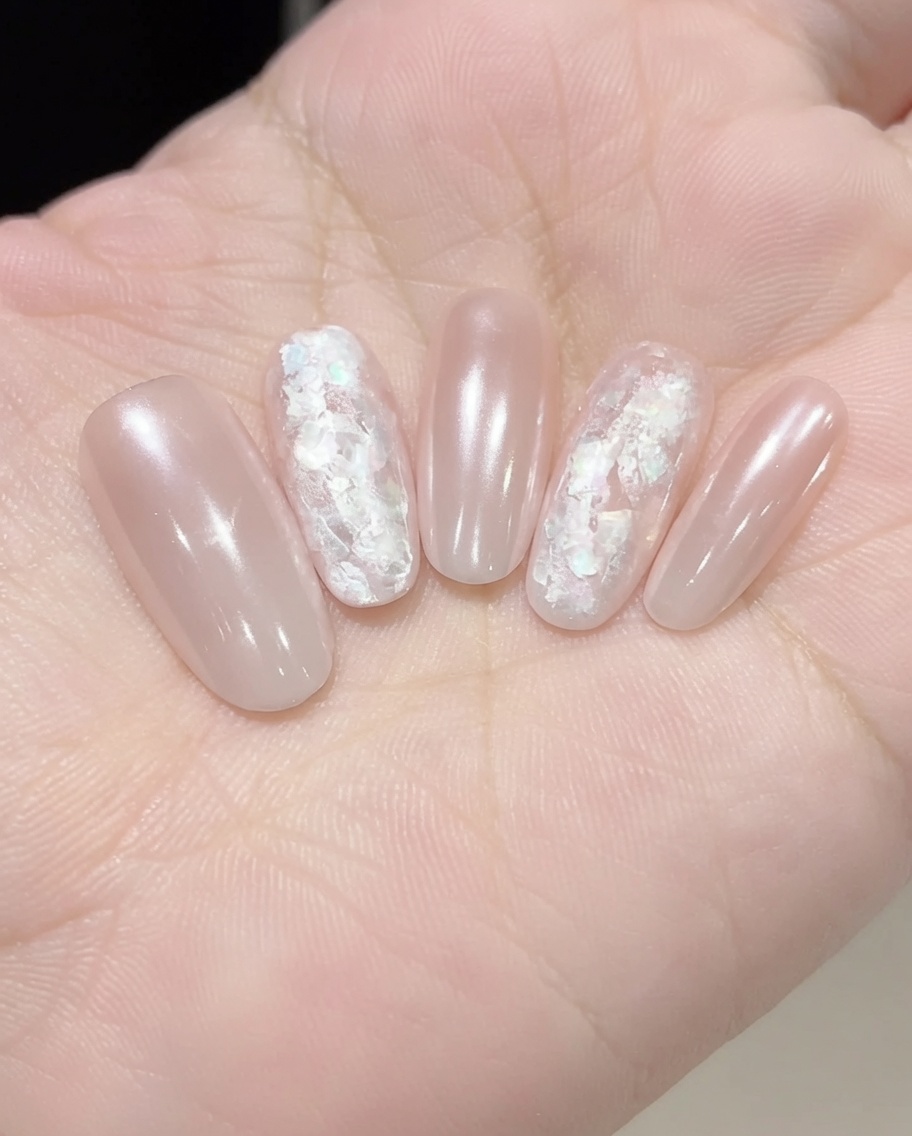 Applying a clear reinforcing gel over embedded nail art to smooth and seal the surface.