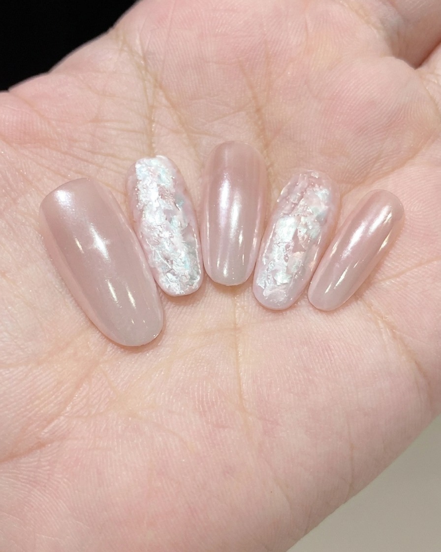 A nail brush applying a thin layer of shimmery Fine Pearl Glue onto a nail.