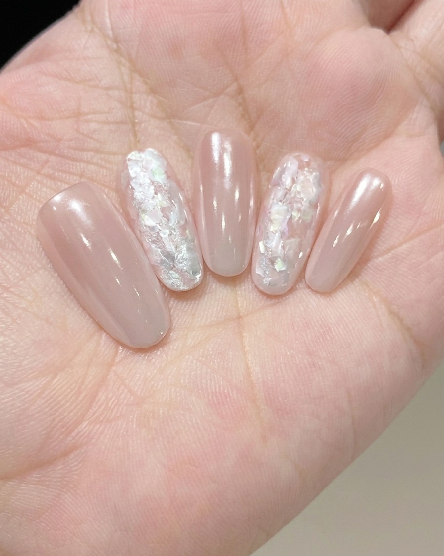 A brush applying a clear, glossy top coat to seal and protect the completed nail design.