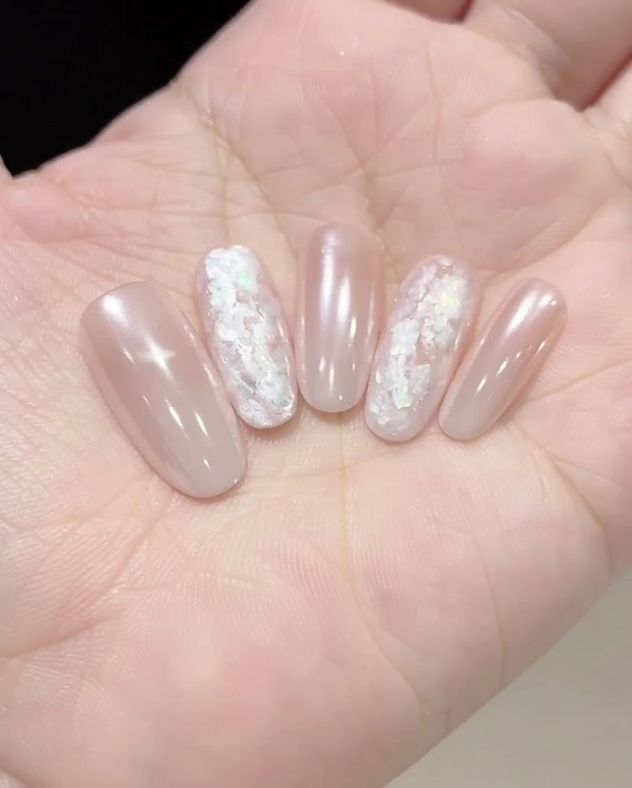 A cosmetic sponge being used to dab color onto the tip of a nail to create a gradient.