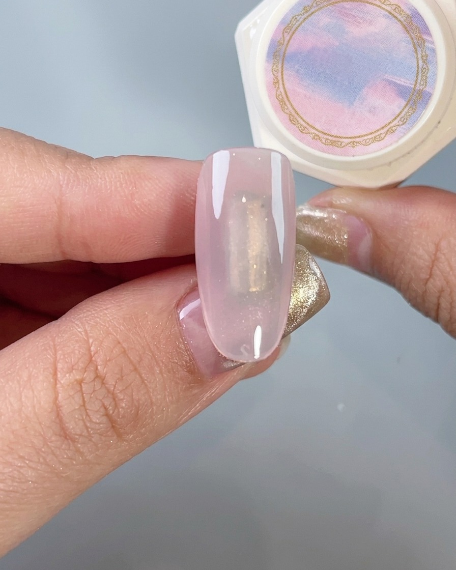 A soft brush gently dusting excess chrome powder off a manicured nail.