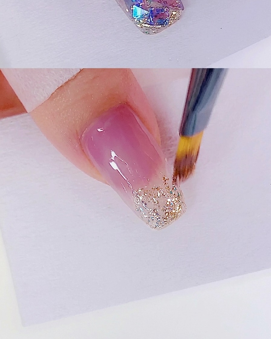 A clean brush blending the glitter gel edge to create a smooth gradient transition.