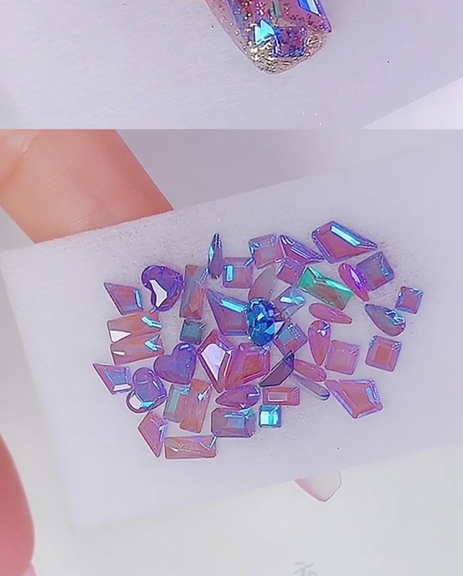 Small dots of clear glue applied to the nail bed to anchor rhinestone decorations.