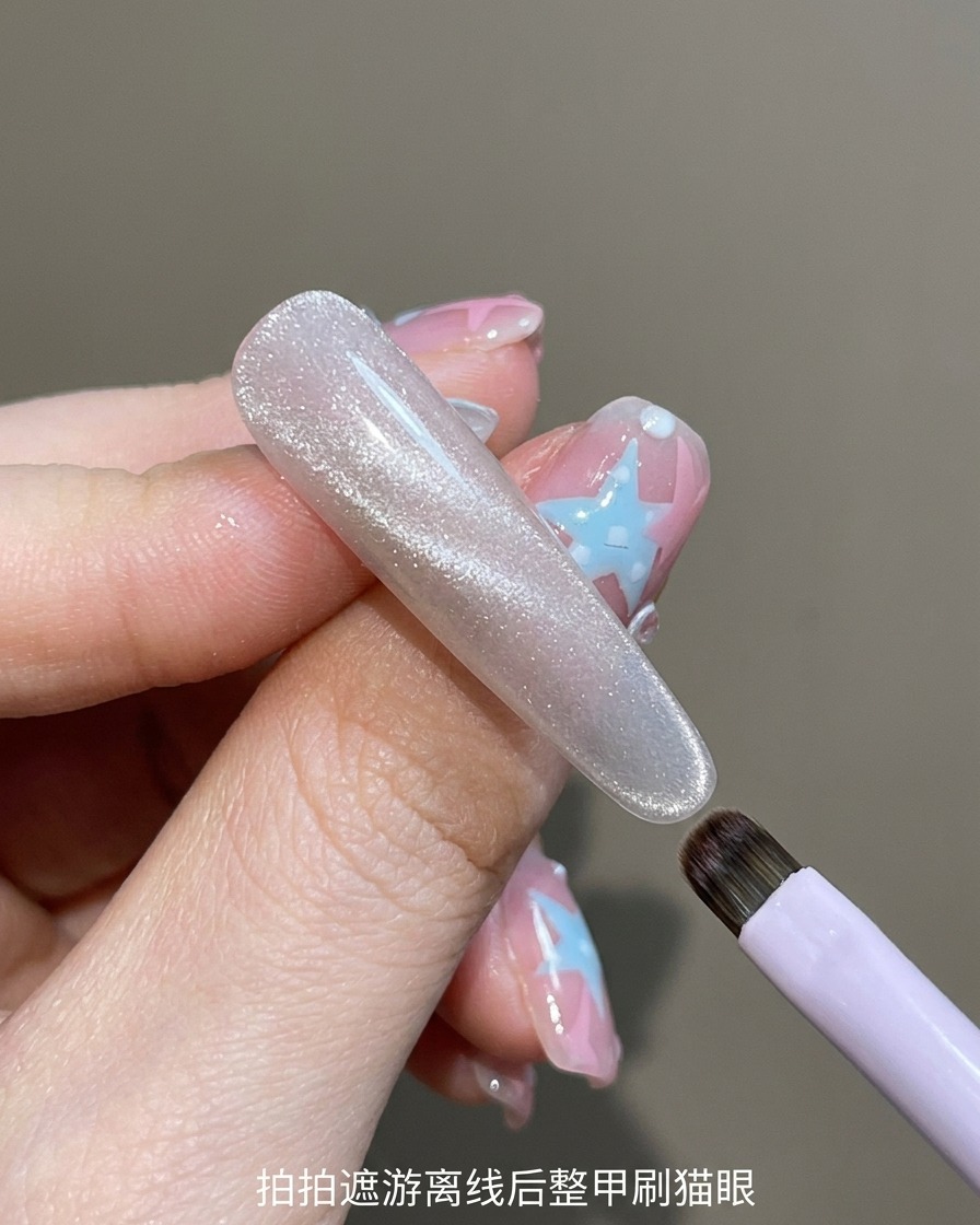 A brush applying a clear, shimmering cat-eye gel polish over a natural nail.