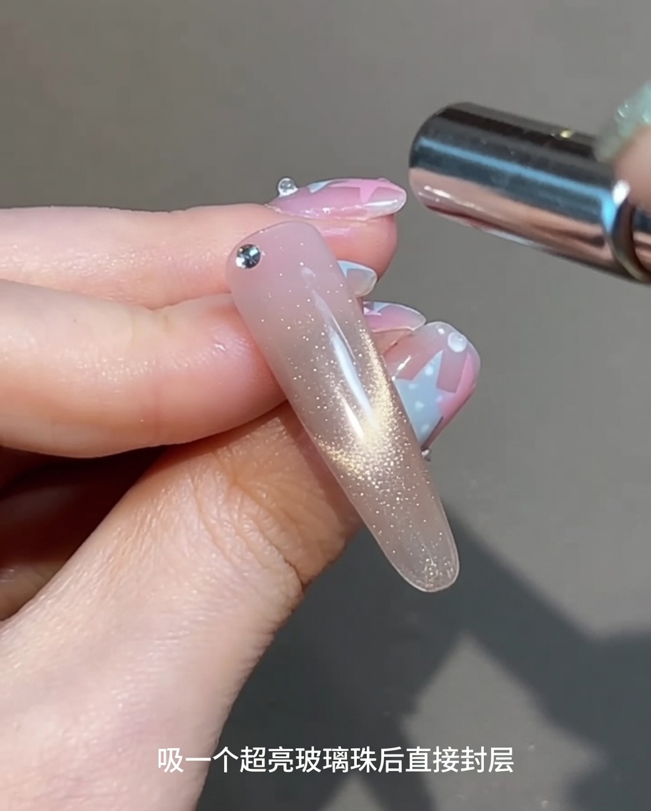 A cylindrical magnet held parallel over a wet gel-coated nail to create a bright, shimmering magnetic highlight.