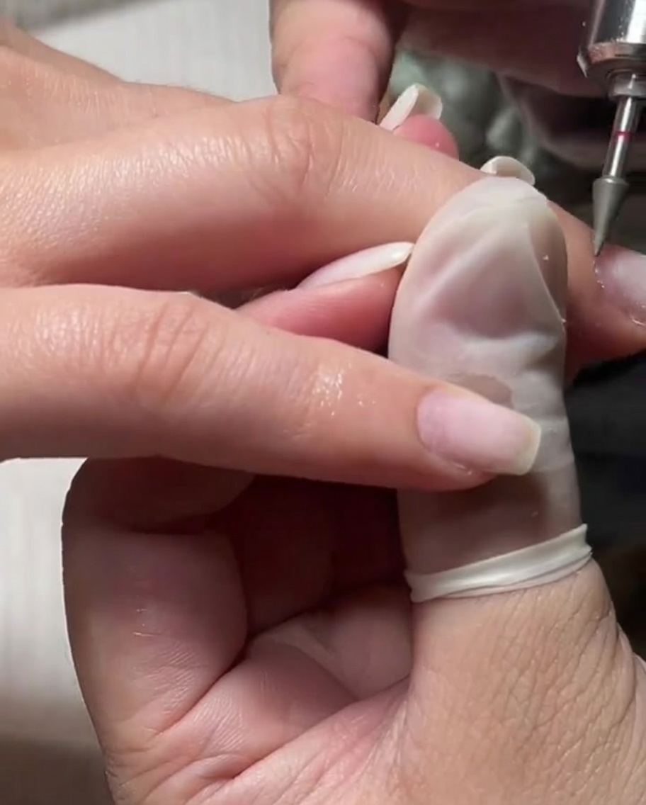 A fine e-file bit being used on a dampened cuticle area for gentle exfoliation.