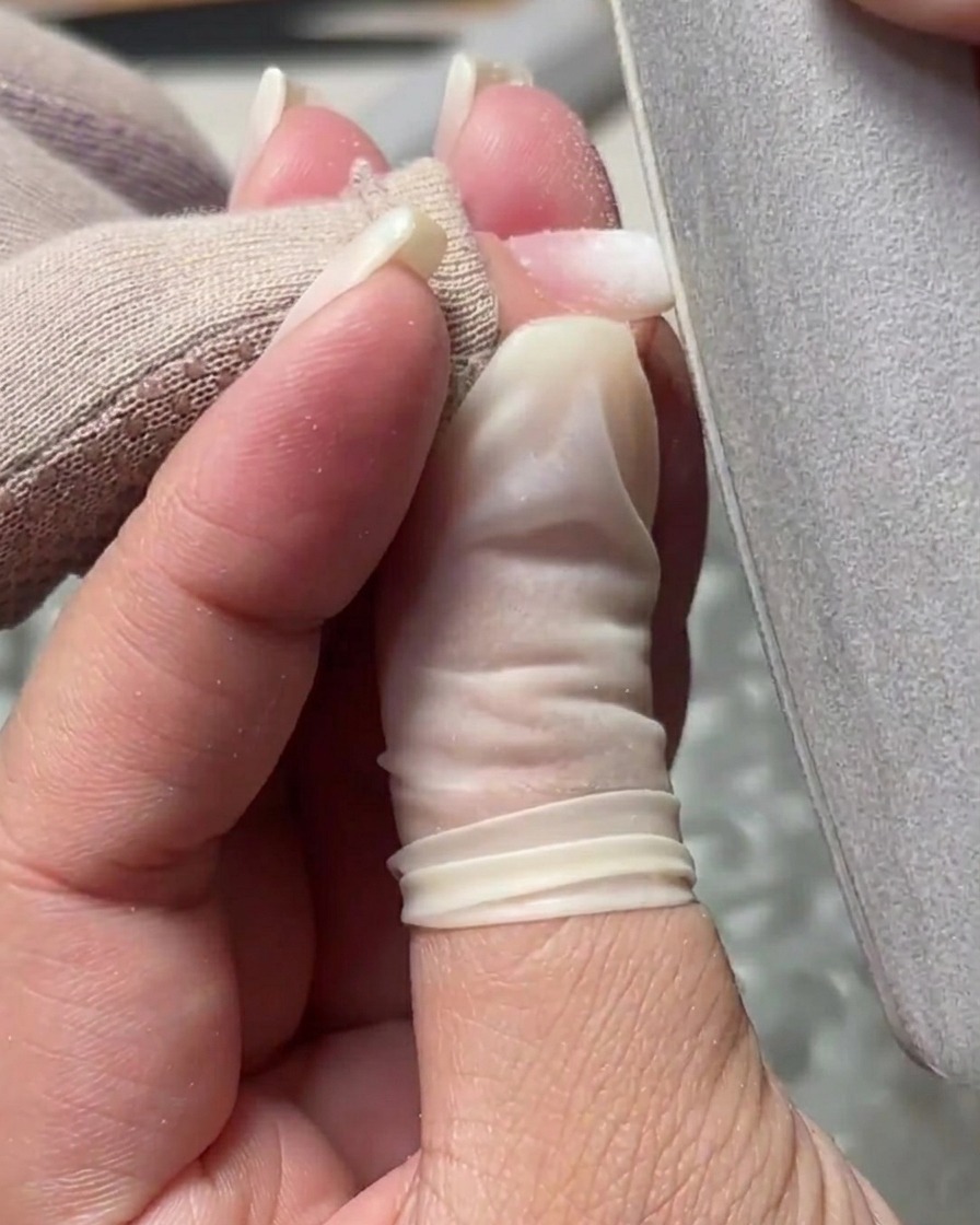 A hand file being used to smooth the surface and refine the edges of a structured gel nail.