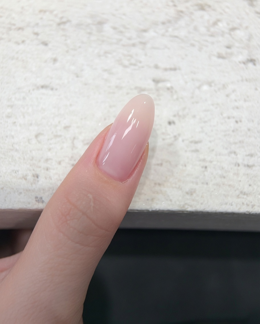 A finger resting inside a UV/LED nail lamp during the curing process.