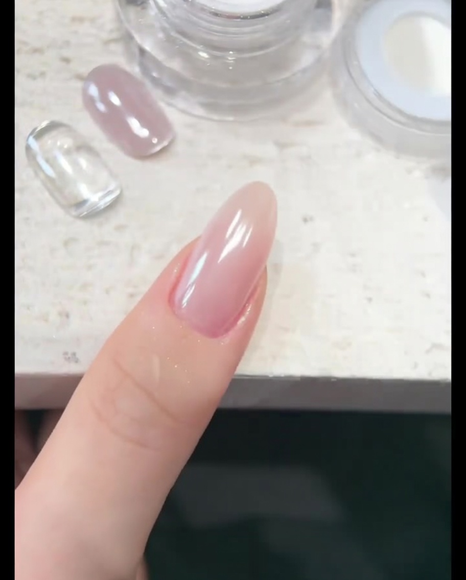 A soft brush delicately clearing away excess chrome powder from the skin and cuticle surrounding the nail.
