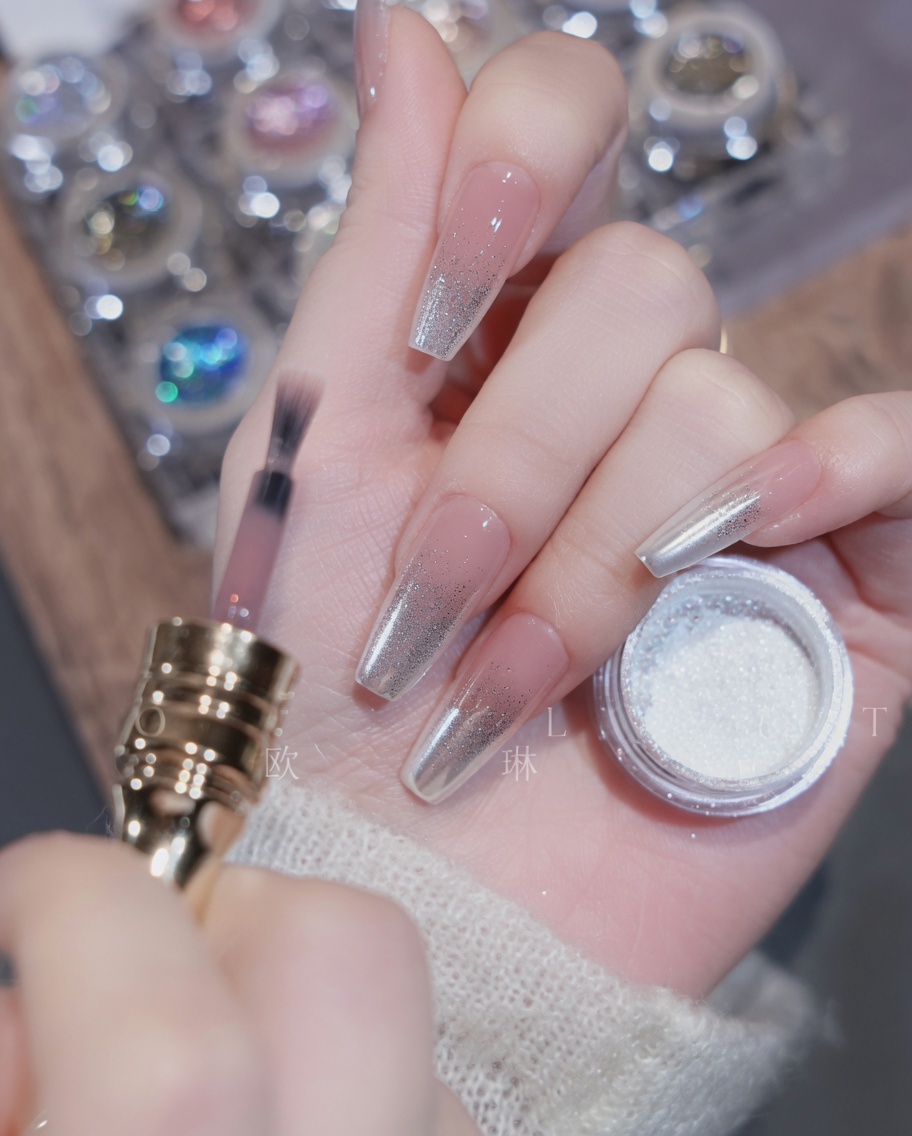 A gradient brush blending the nude gel polish down the length of the nail.