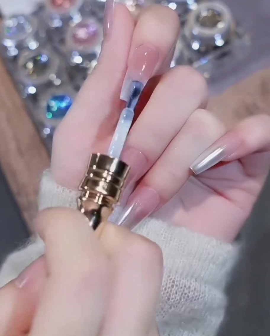 A brush applying white gel polish to the free edge of the nail.